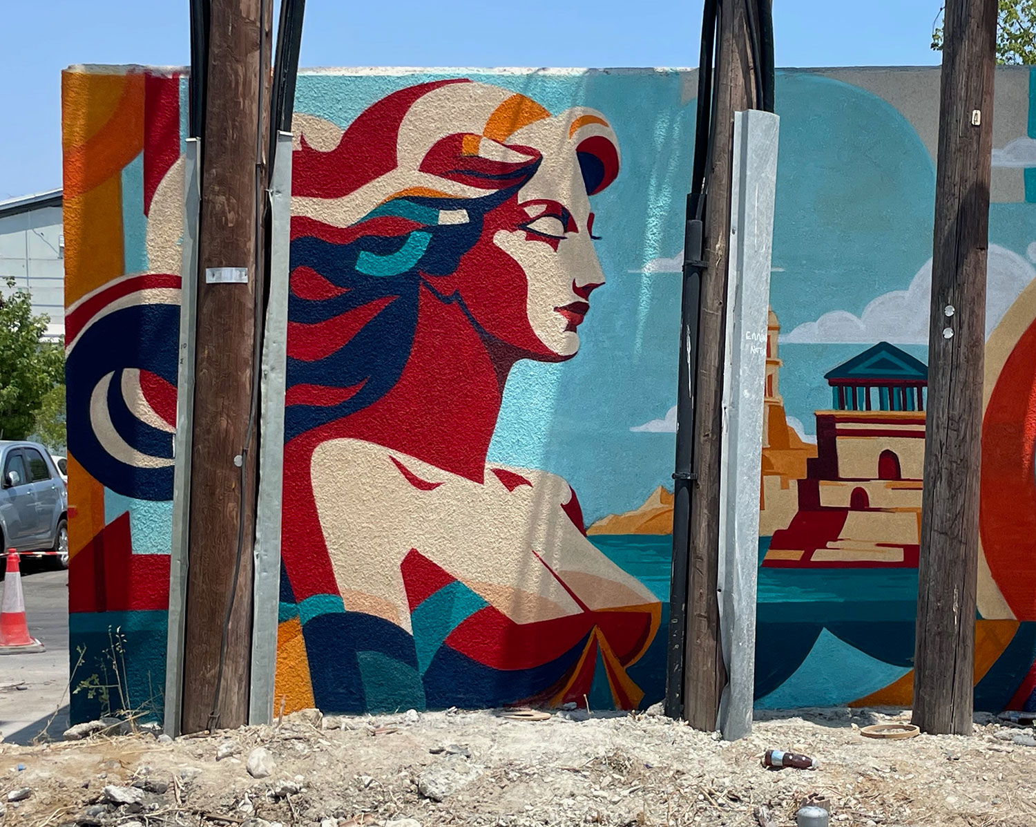 Woman and coastal landmarks painted on an urban utility structure
